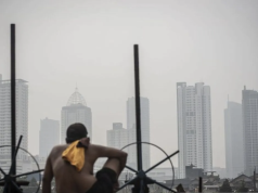 Kualitas Udara Jakarta Kamis Pagi Jadi yang Terburuk di Dunia, Lampaui Santiago dan Kampala Ilustrasi - Seorang warga berjemur dengan latar belakang gedung bertingkat tersamar kabut polusi udara di Jakarta. ANTARA FOTO/Aprillio Akbar/rwa/aa.
